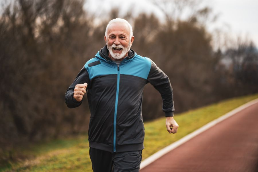 middle aged man smiling while he runs